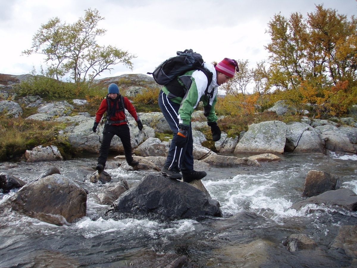 Marianne ser hvor langt ho klarer å lene seg framover før ho stuper i elva